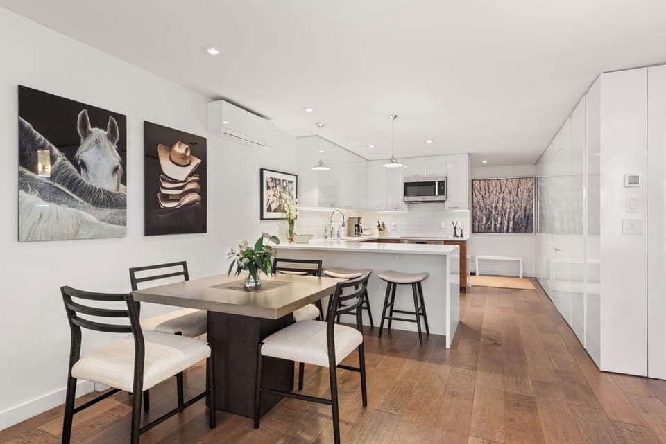 Open-concept kitchen, living, and dining room with gas fireplace and high-end finishes.