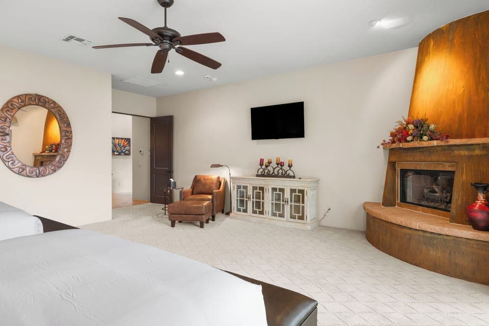 The primary bedroom features 2 queen beds, patio access, TV, fireplace and an ensuite bathroom.