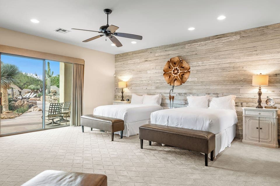 The primary bedroom features 2 queen beds, patio access, TV, fireplace and an ensuite bathroom.