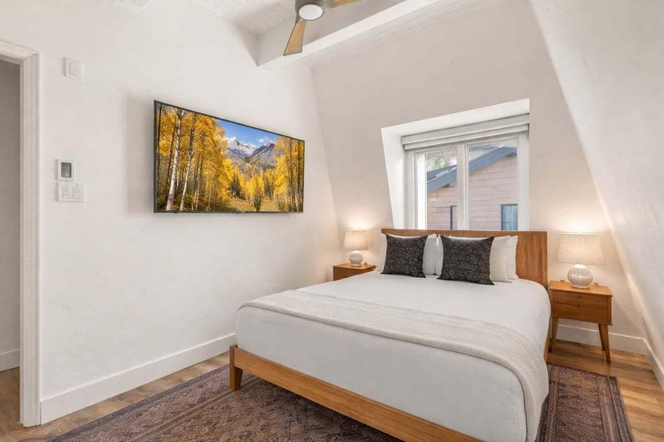 Guest bedroom with queen-sized bed, 55" Smart TV, closet, Aspen Mountain views, and shared bathroom.