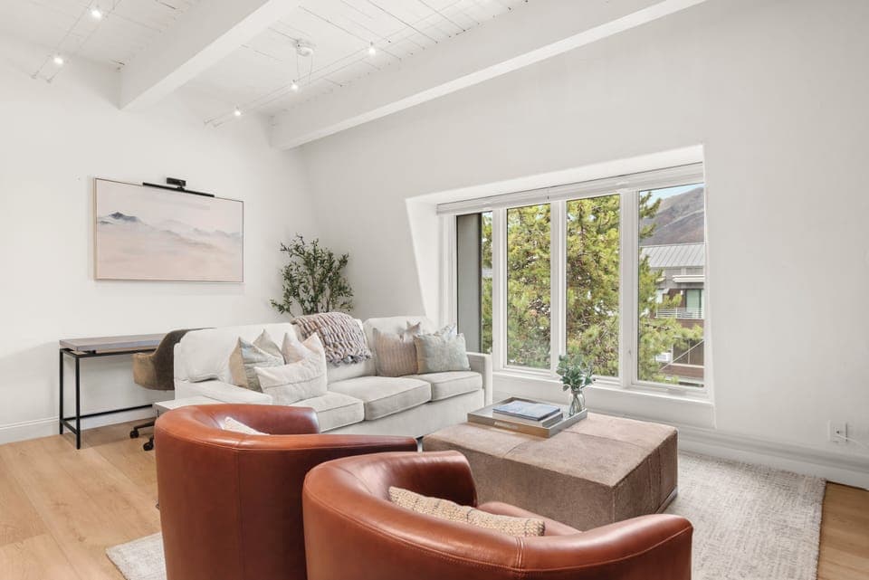 Top-floor sanctuary at Chateau Dumont. This living room features a 65" smart TV with Xfinity cable and Roku Streaming, queen-sized pull out couch, wood-burning fireplace, views of Smuggler and Red Mountain.