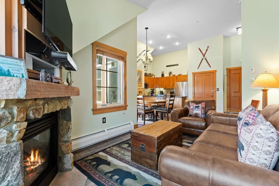 Sink into plush leather sofas beside your crackling stone fireplace, where rustic charm meets open-concept comfort with mountain-inspired décor welcoming you home.