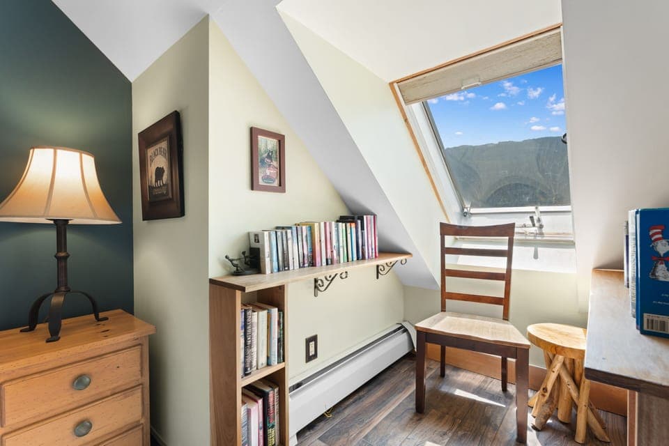 A cozy reading nook with dramatic mountain views through the skylight, perfect for relaxing with your favorite book on a sunny afternoon.