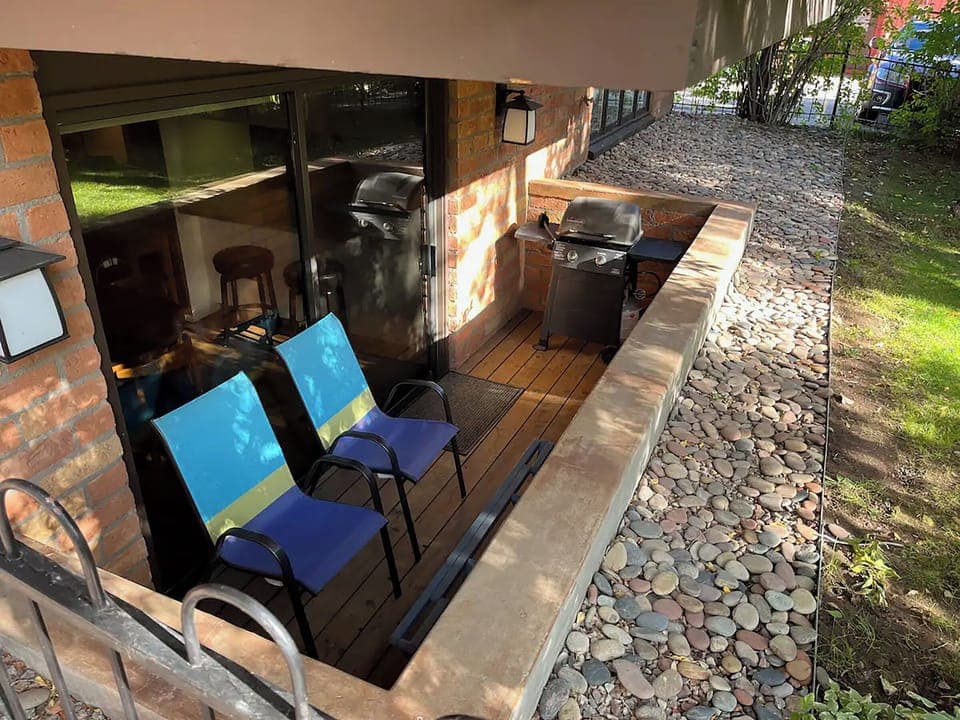 Side deck with gas grill and private yard.